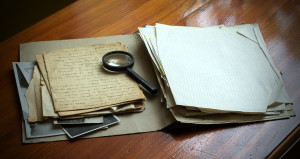 Vintage documents with magnifying glass investigation concept
